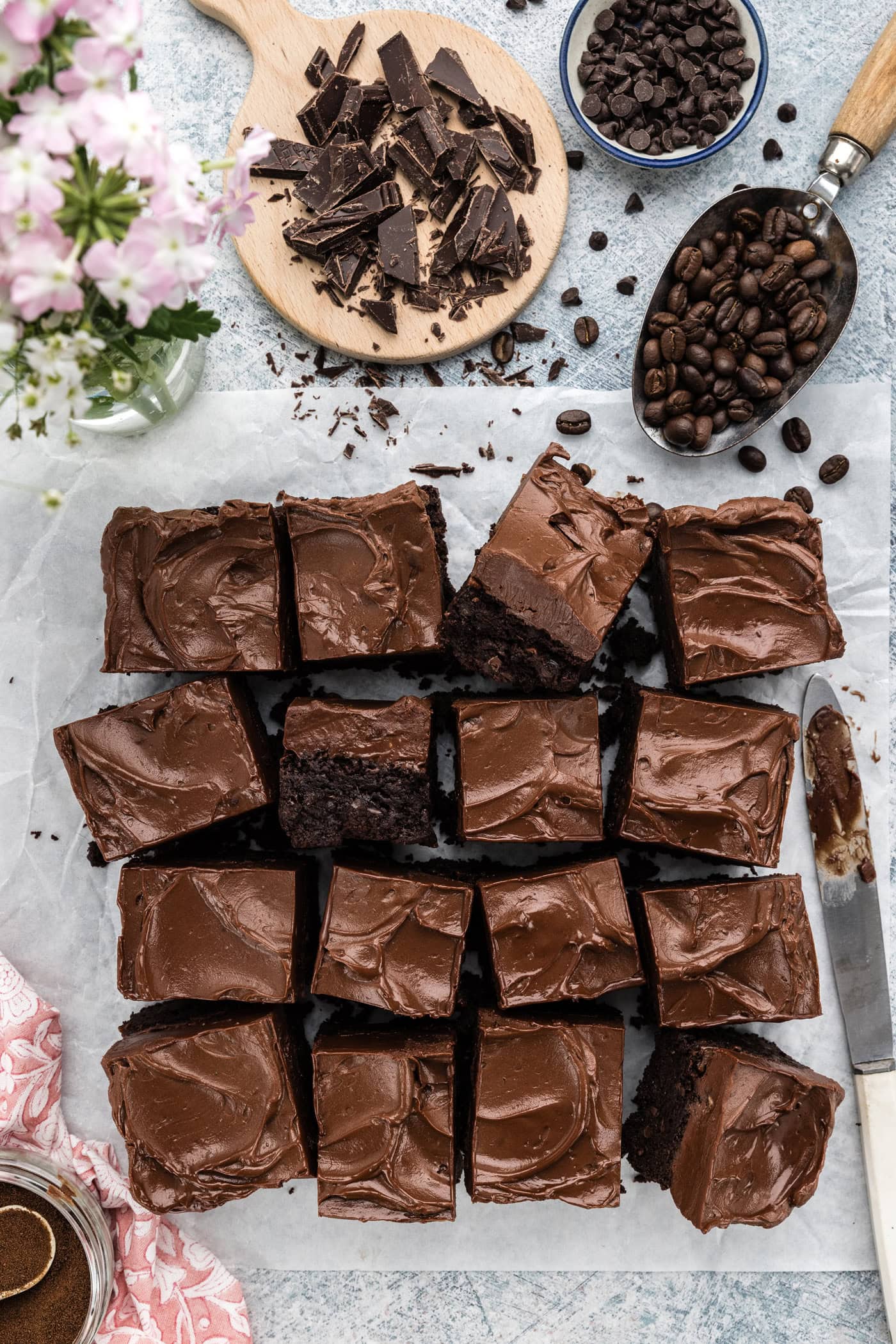 Fudge Frosted Espresso Brownies cut into squares on parchment paper