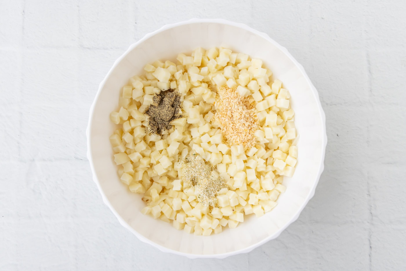 diced potatoes with seasonings in a bowl