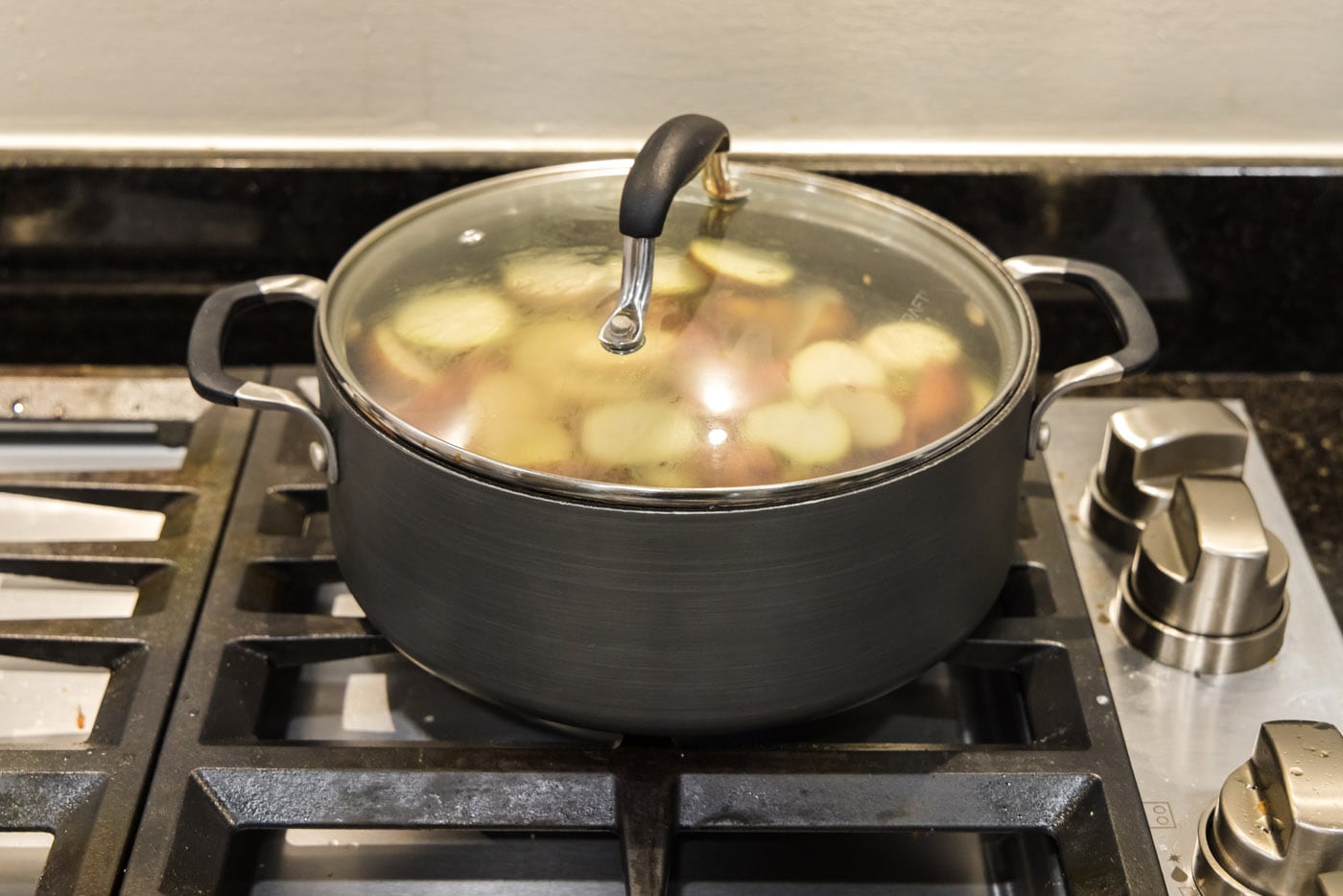 pot of red baby potatoes cooking with the lid
