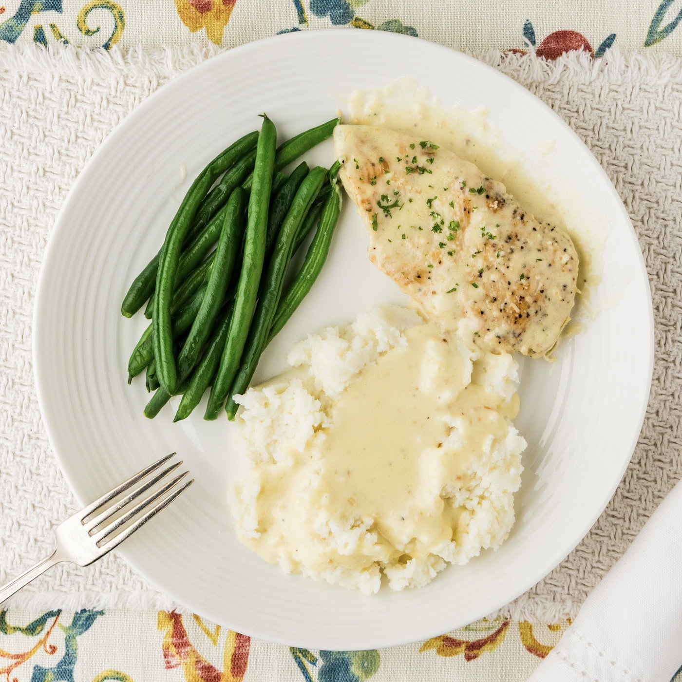 Garlic Parmesan Chicken plated with mashed potatoes and green beans