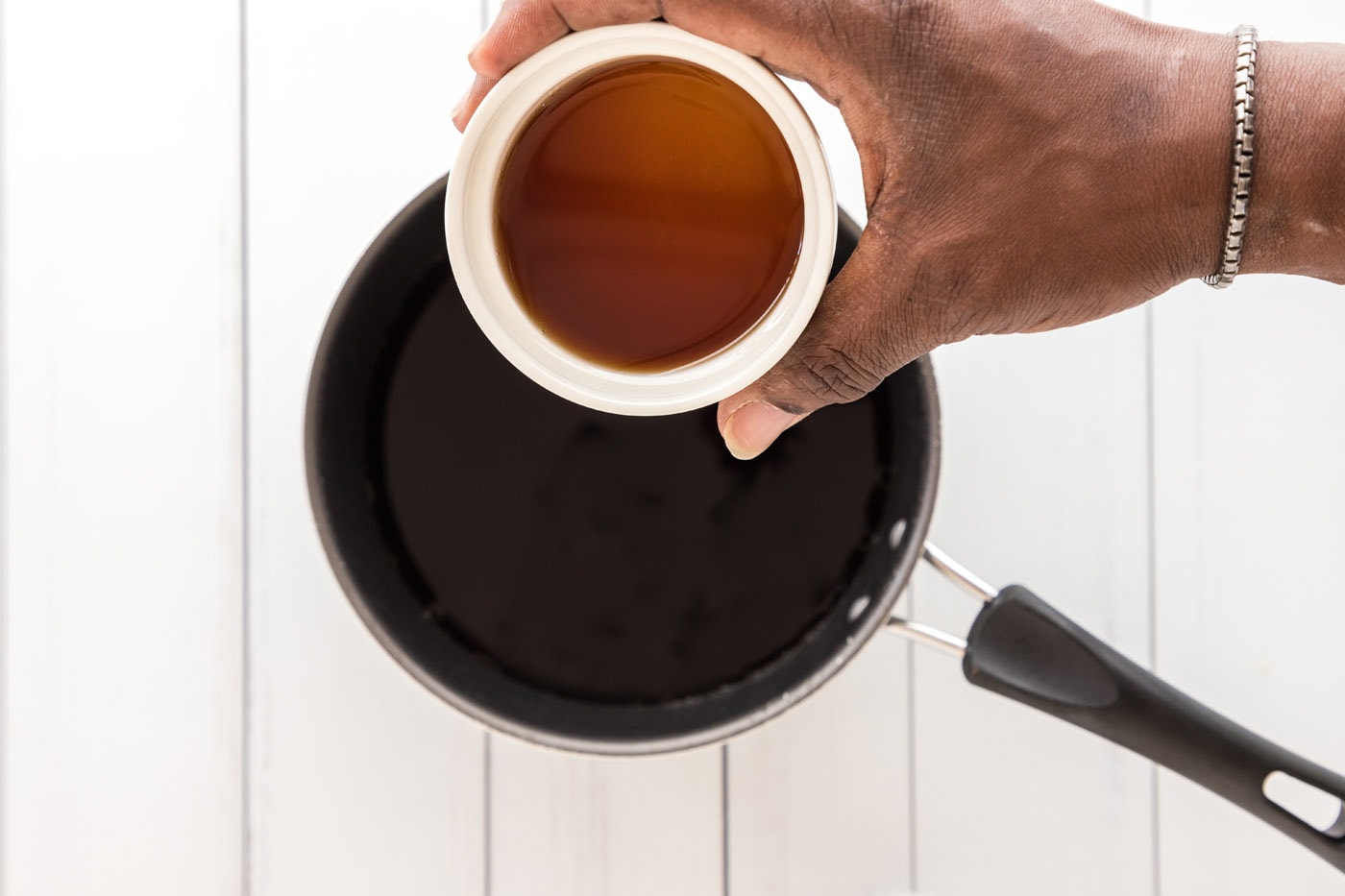pouring sauce into saucepan
