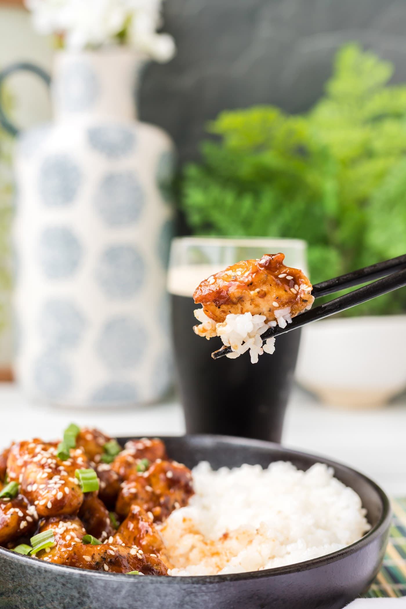 lifting General Tso Chicken with chopsticks