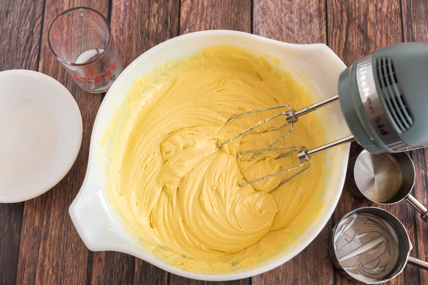 lemon cake batter in a mixing bowl with whisk beaters