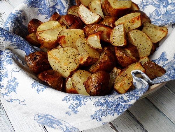 A close up photo of cut up roasted potatoes.