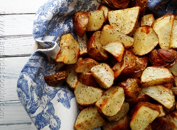 A close up photo of cut up roasted potatoes.