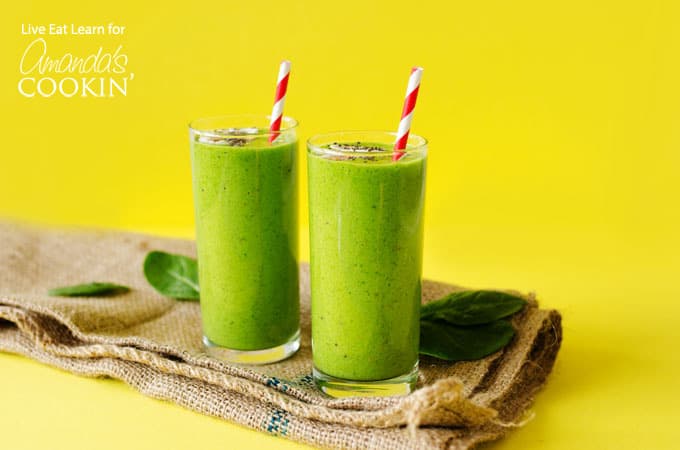 Green smoothies on yellow background with paper straws