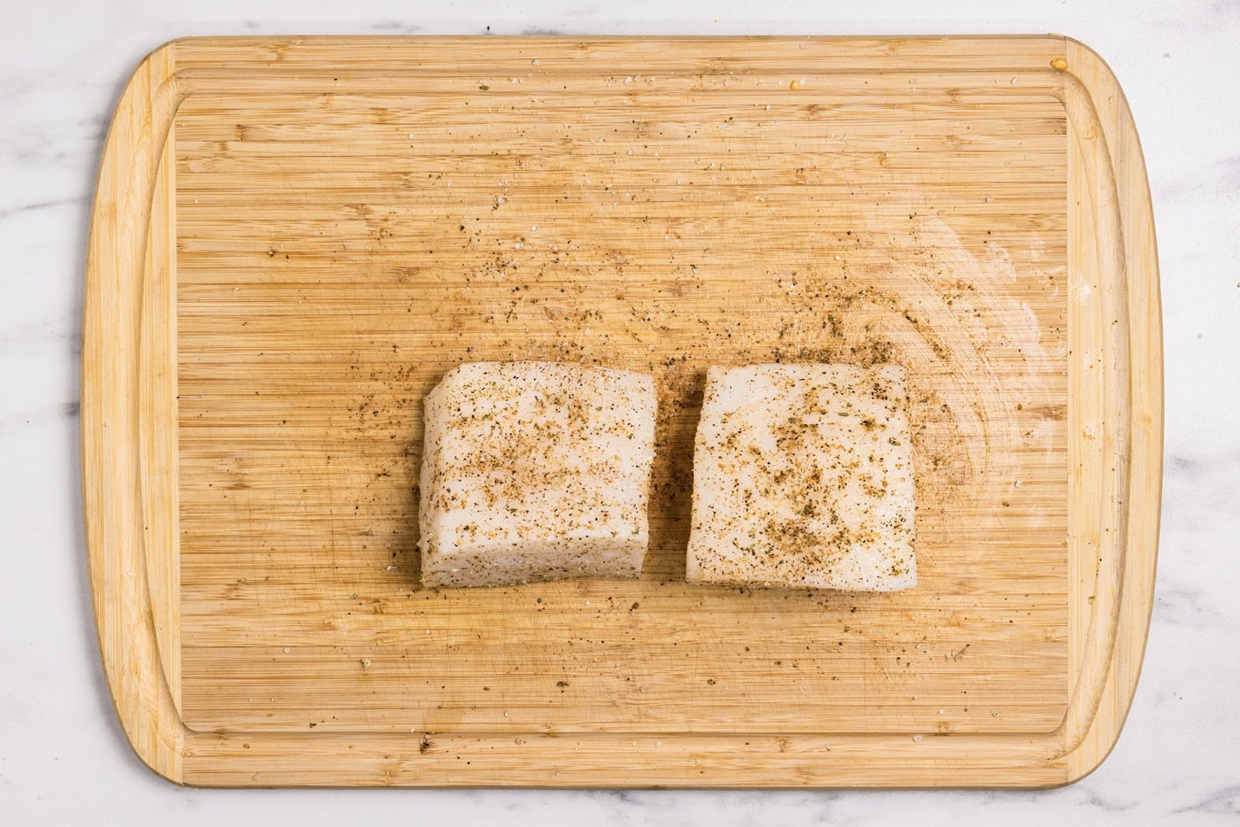 seasoned chilean sea bass filets on a cutting board