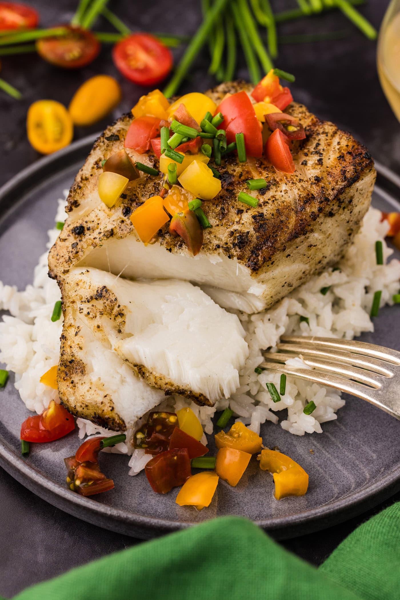 Grilled Chilean Sea Bass broken apart over a bed of rice