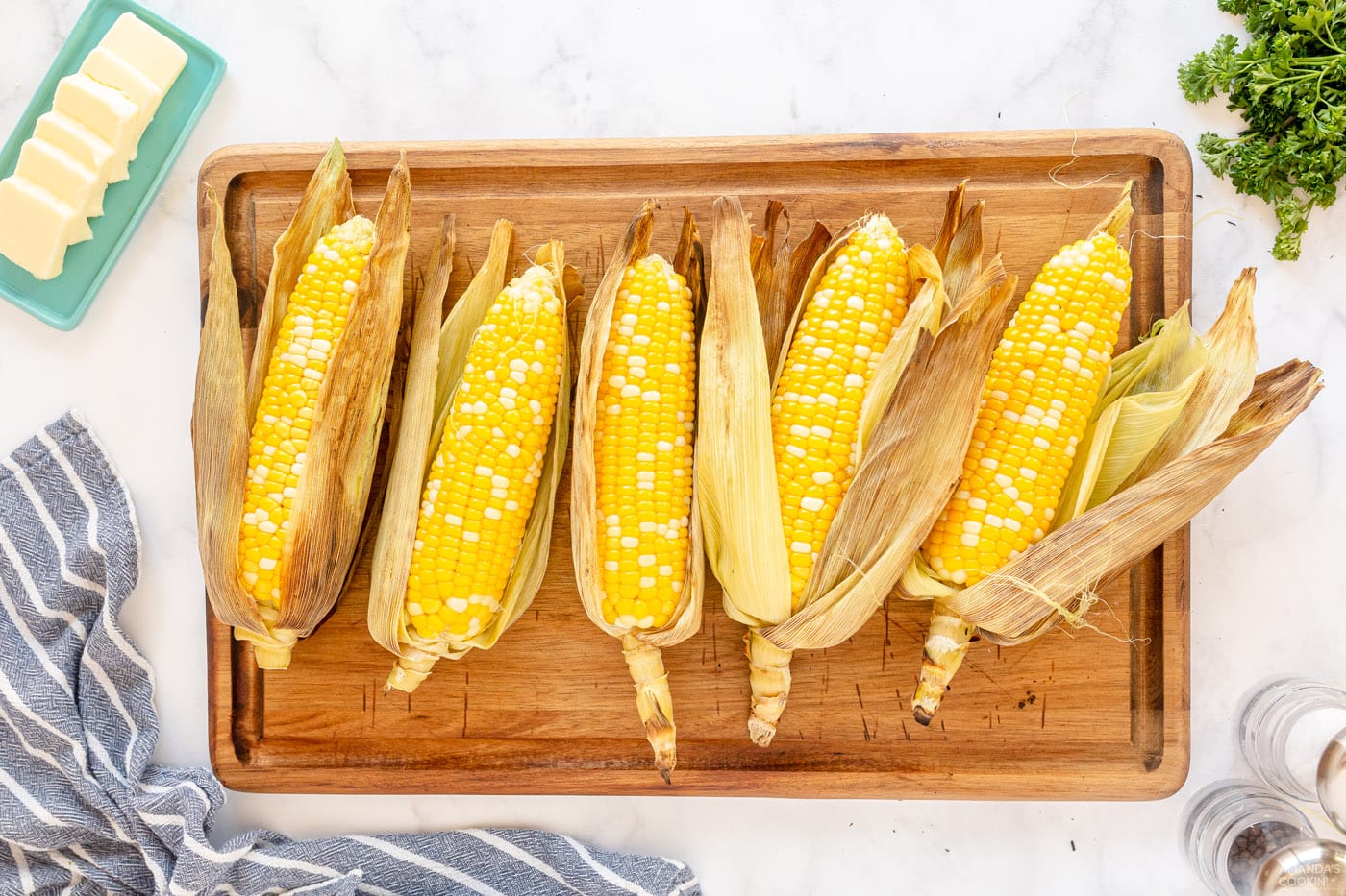 peeled corn on the cob on a cutting board