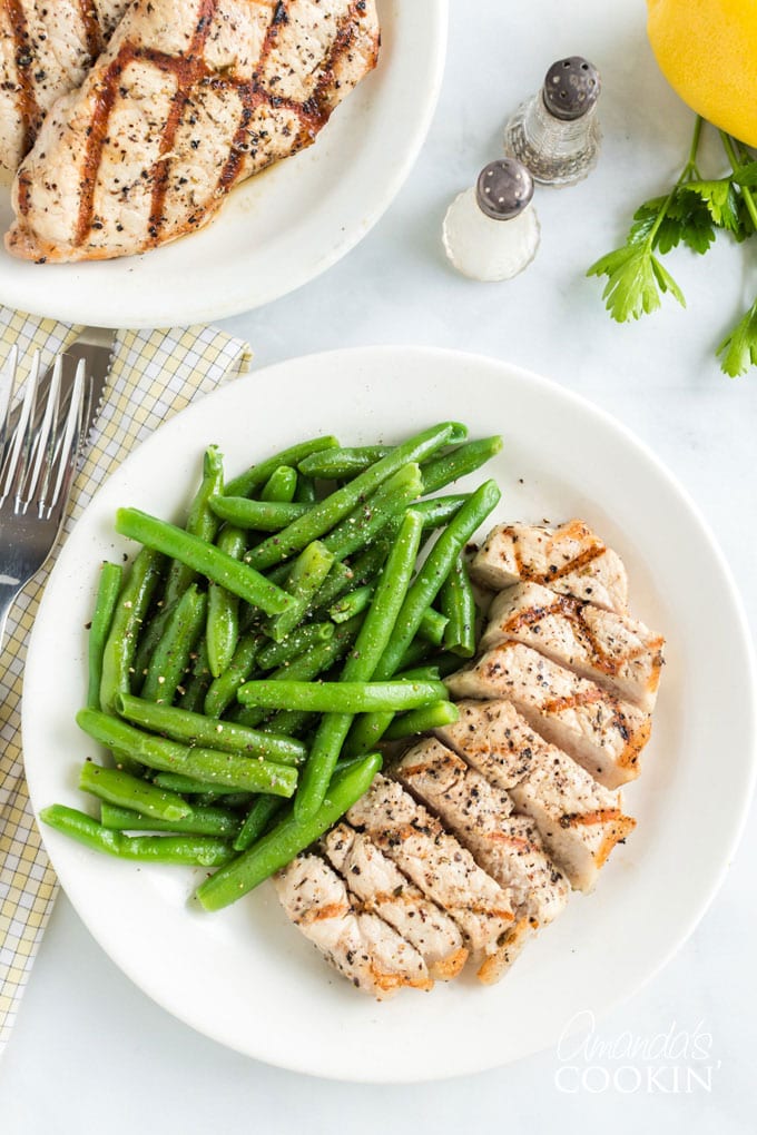 sliced pork chop on a plate with green beans