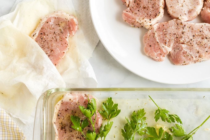 pork chops being dried off with paper towels