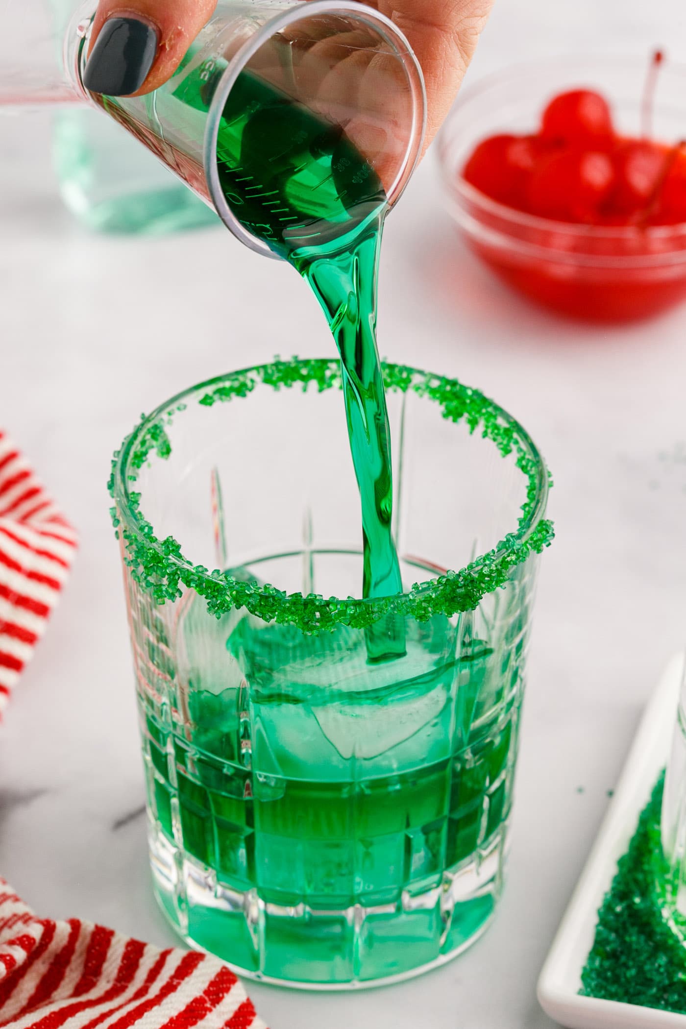 pouring midori into rock glass