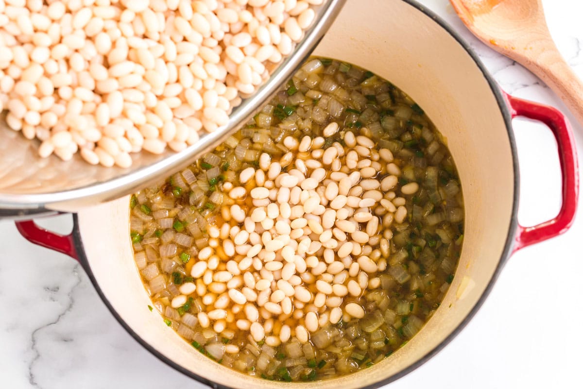 adding beans to onion mixture in pan