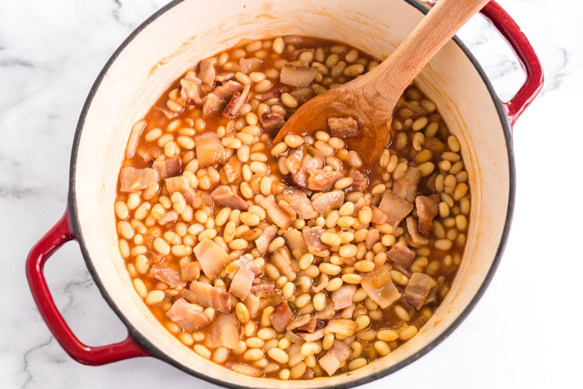 stirring the bean mixture with a wooden spoon