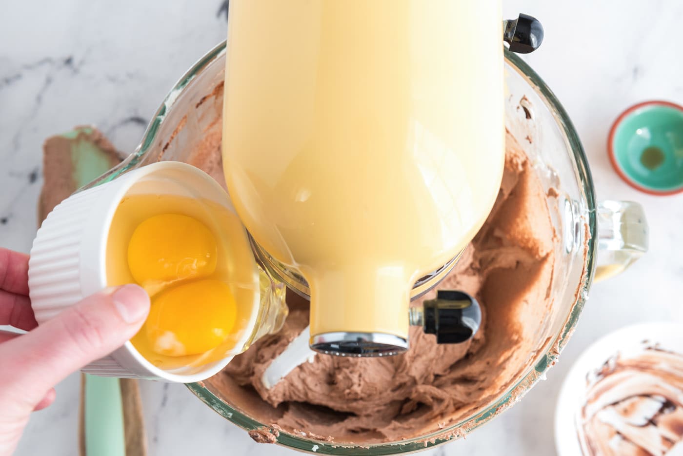 adding eggs to french silk pie in a stand mixer bowl