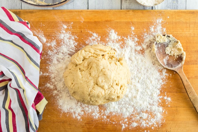 pizza dough on floured wooden board