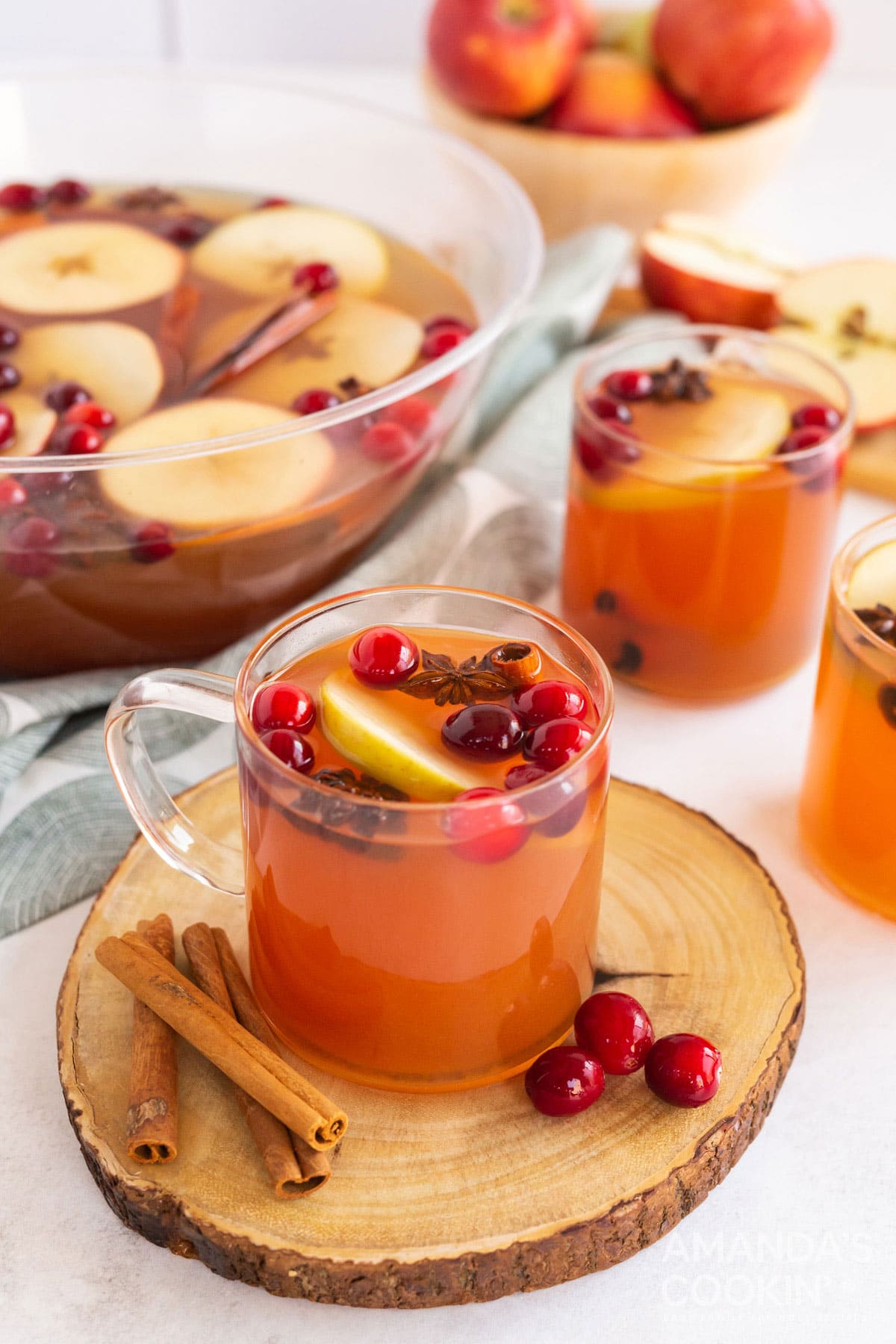glass mug of hot apple cider on a wooden tray