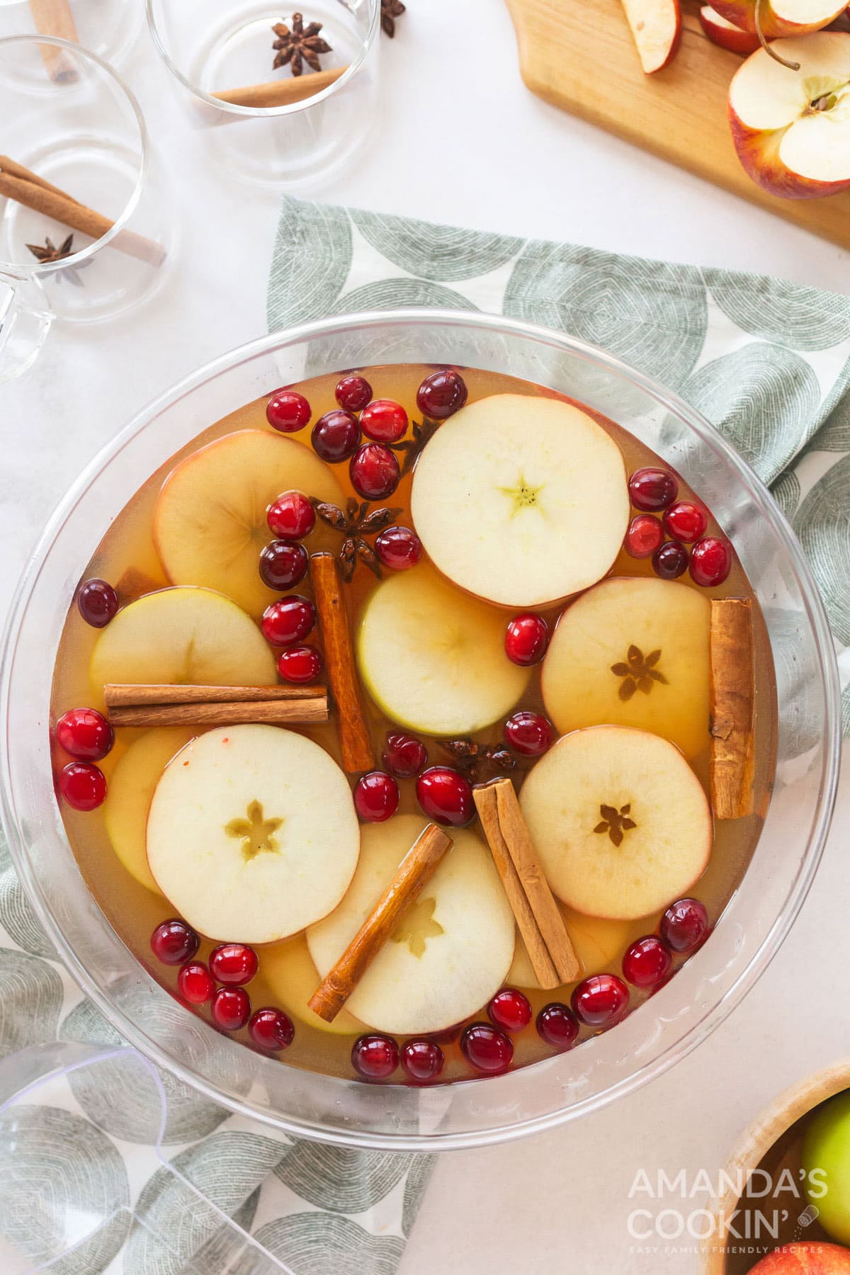 overhead view of a punch bowl filled with hot apple cider and garnished with apple slices