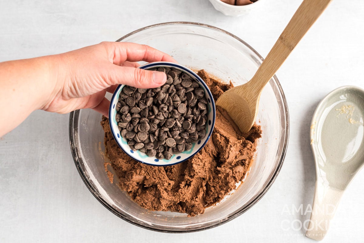 adding chocolate chips to cookie dough