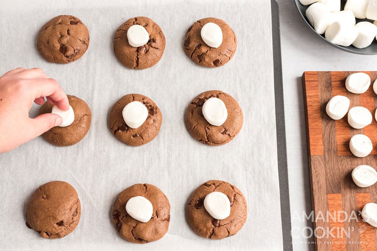 pressing marshmallows onto cookies