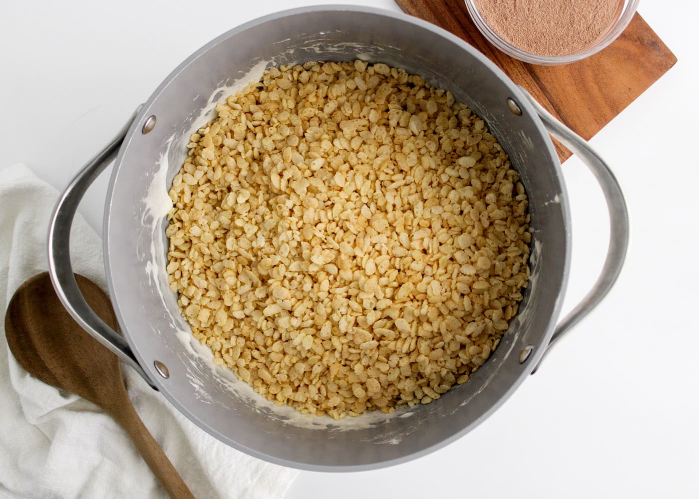 adding rice krispie cereal to marshmallow mixture