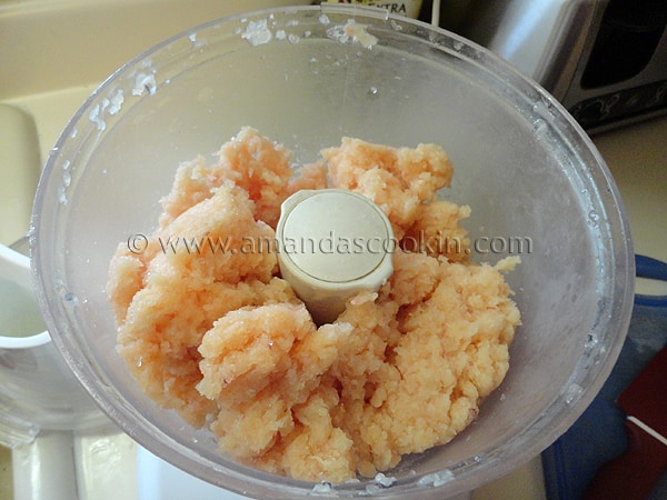 A photo of raw chicken in a food processor.