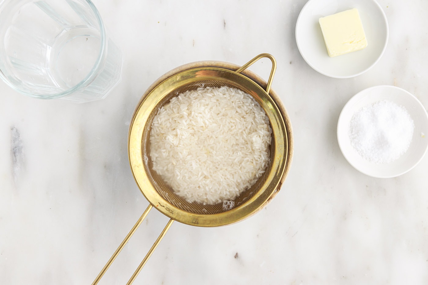 rinsing rice with water in a sieve