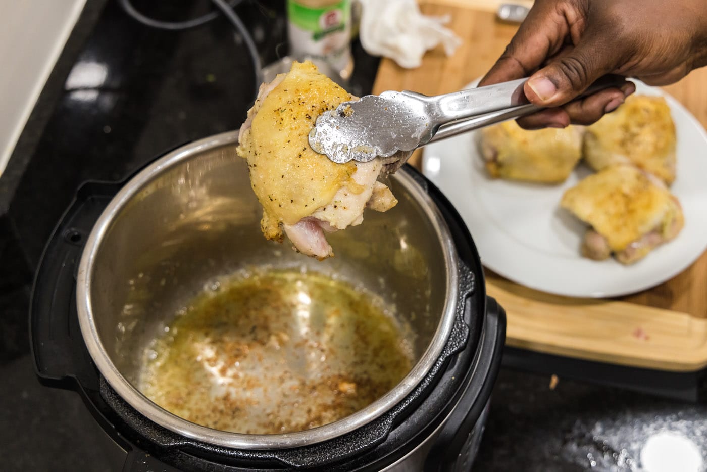 seared chicken on tongs over instant pot