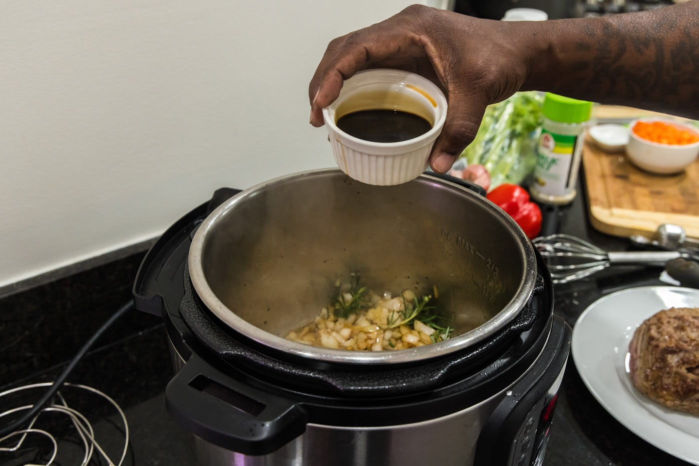 pouring soy sauce into instant pot with onion. mixture