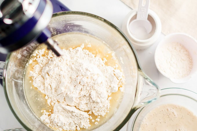 bread dough and flour in the bowl of a stand mixer