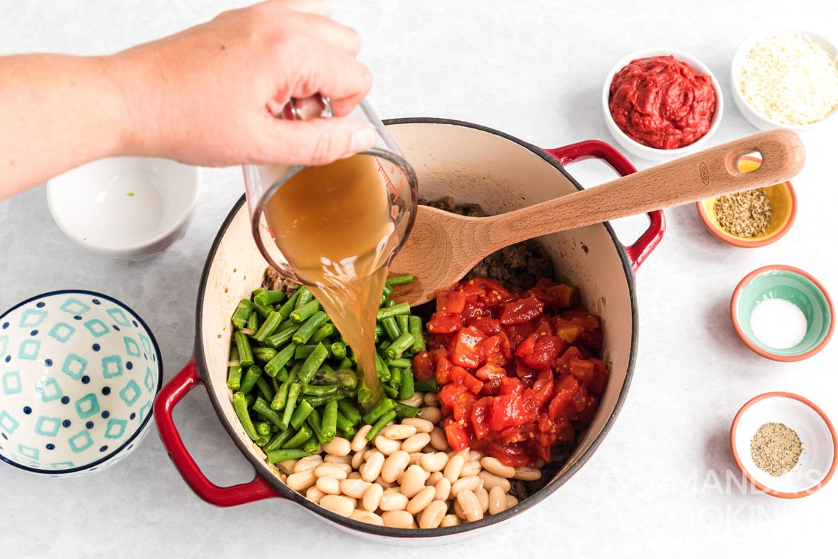 pouring vegetable broth into pot
