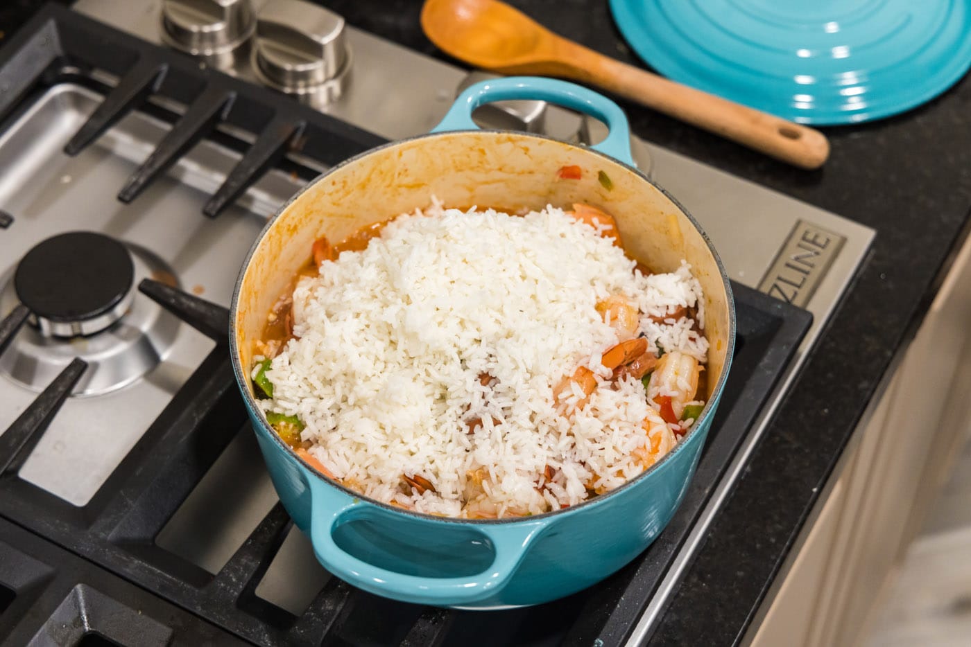 white rice on top of jambalaya in a dutch oven