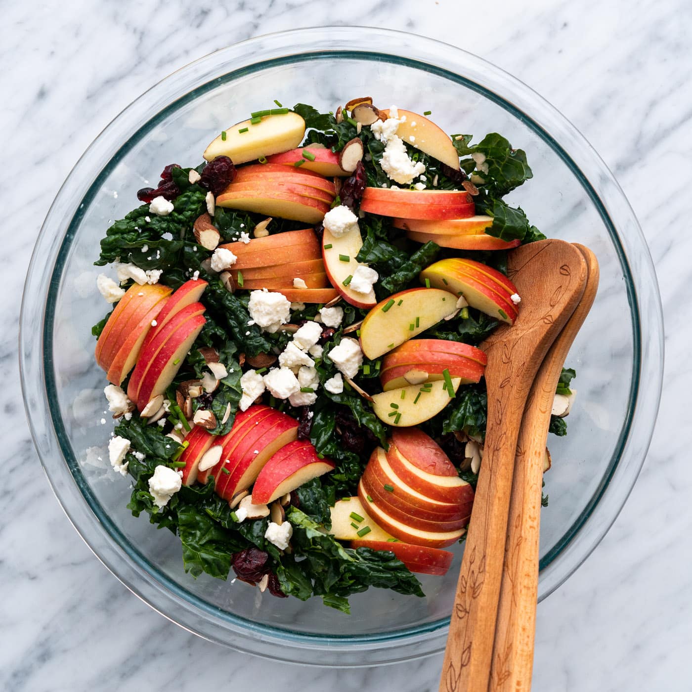 Bowl of Kale Salad with serving spoons in the bowl