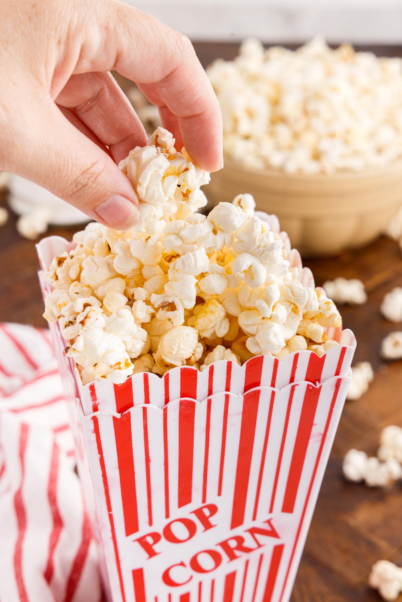 Hand grabbing Kettle Corn out of a popcorn bucket