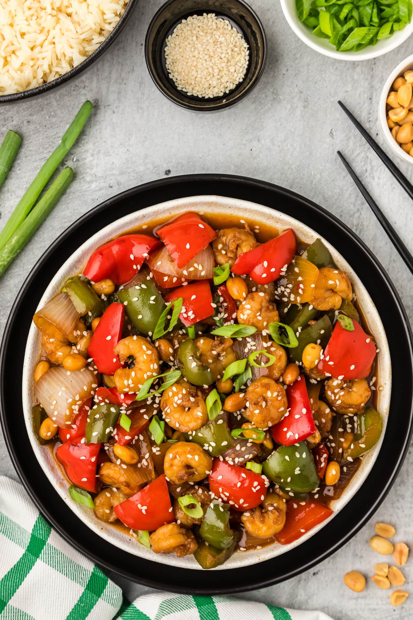 Plate of Kung Pao Shrimp with rice and peanuts on the side