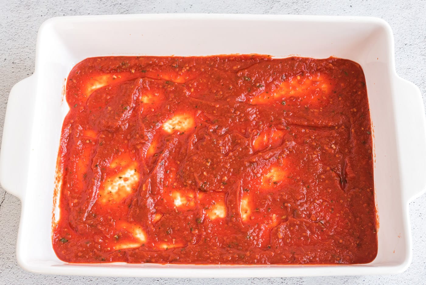 toamato sauce on bottom of baking dish