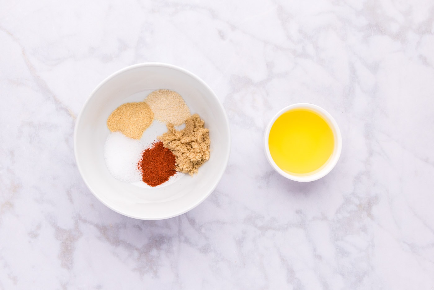 seasonings in a bowl next to olive oil