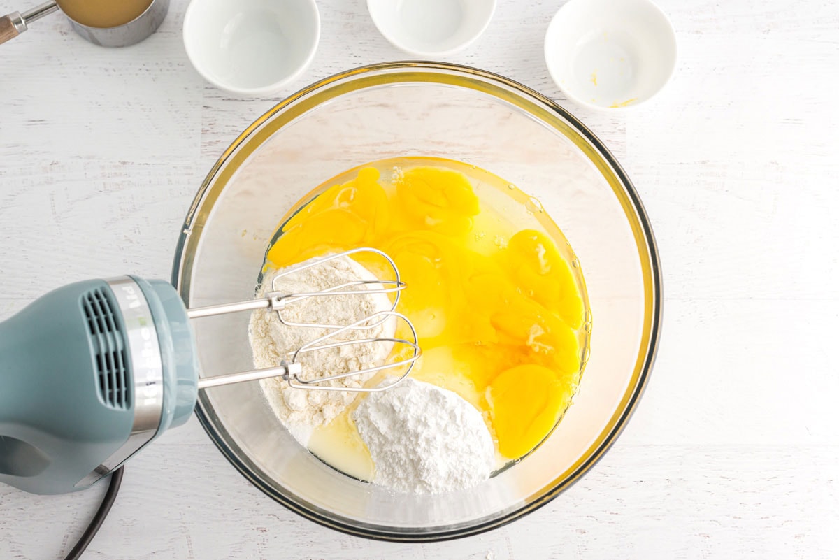 eggs and other ingredients in a bowl with a mixer