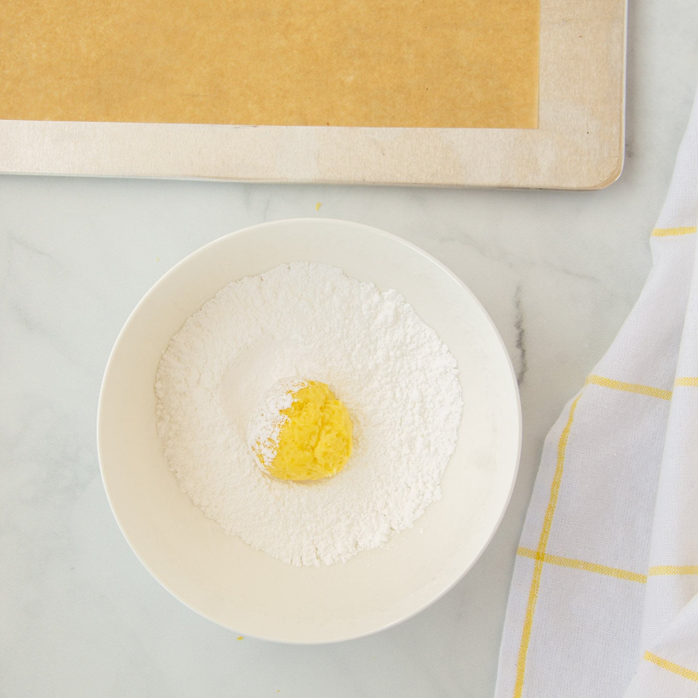 rolling lemon cookies in powdered sugar
