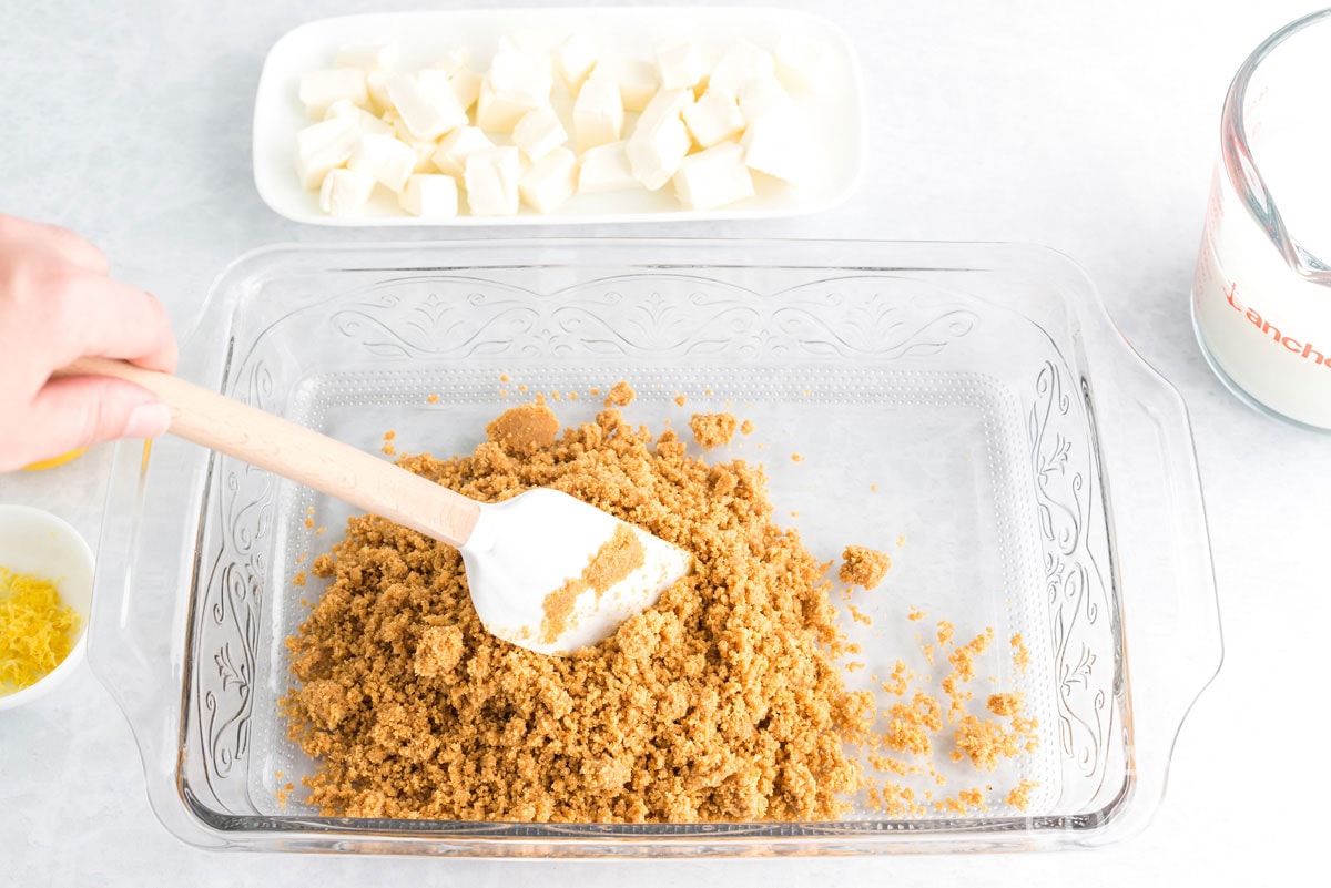 adding crumbs to a baking pan