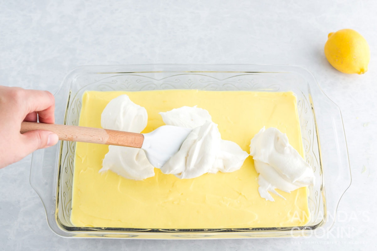 spreading whipped cream over pudding layer