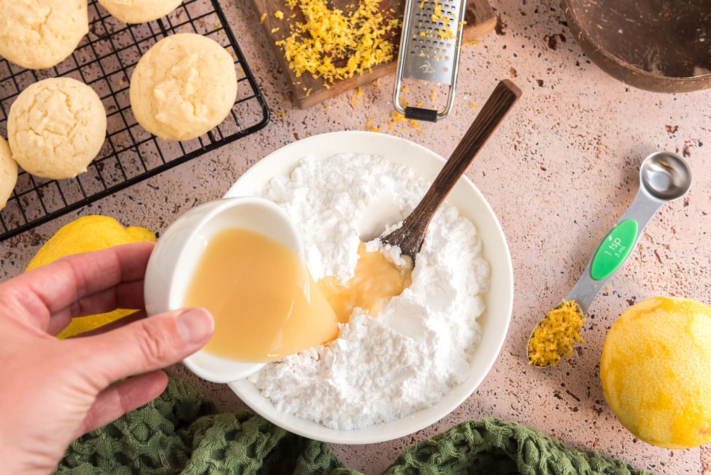 pouring lemon juice into powdered sugar