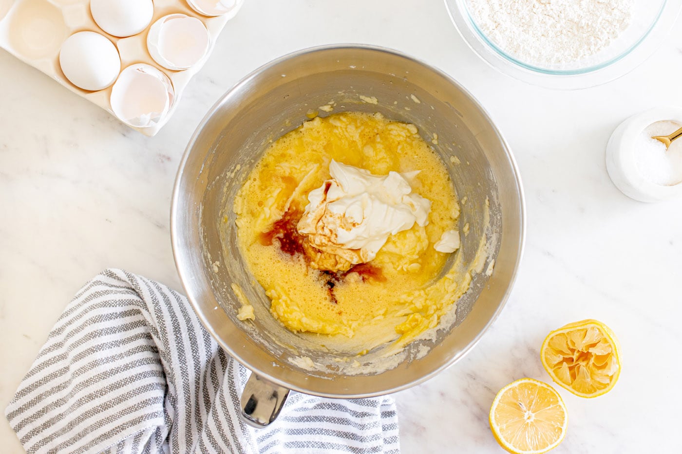 adding sour cream and vanilla to butter mixture in a bowl