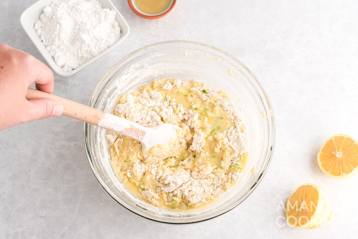stirring dry ingredients into zucchini bread batter