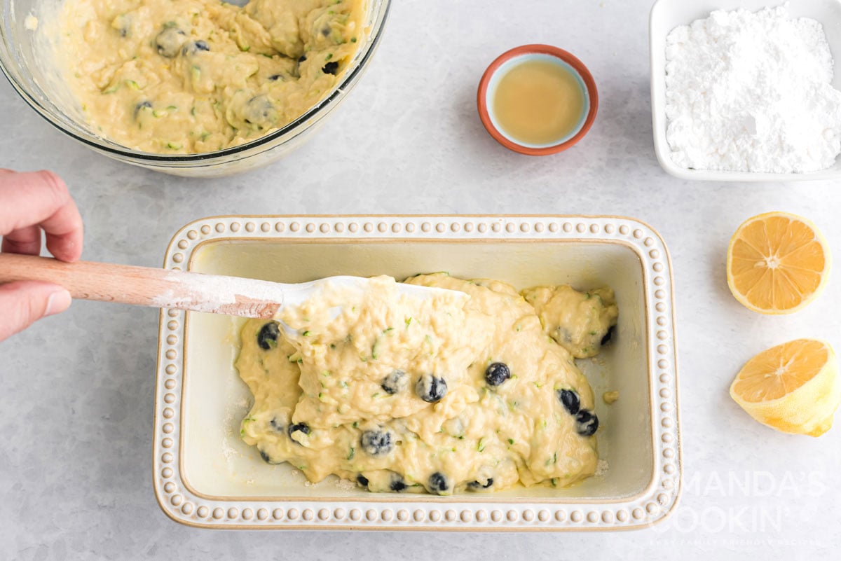 adding lemon blueberry zucchini bread to pan