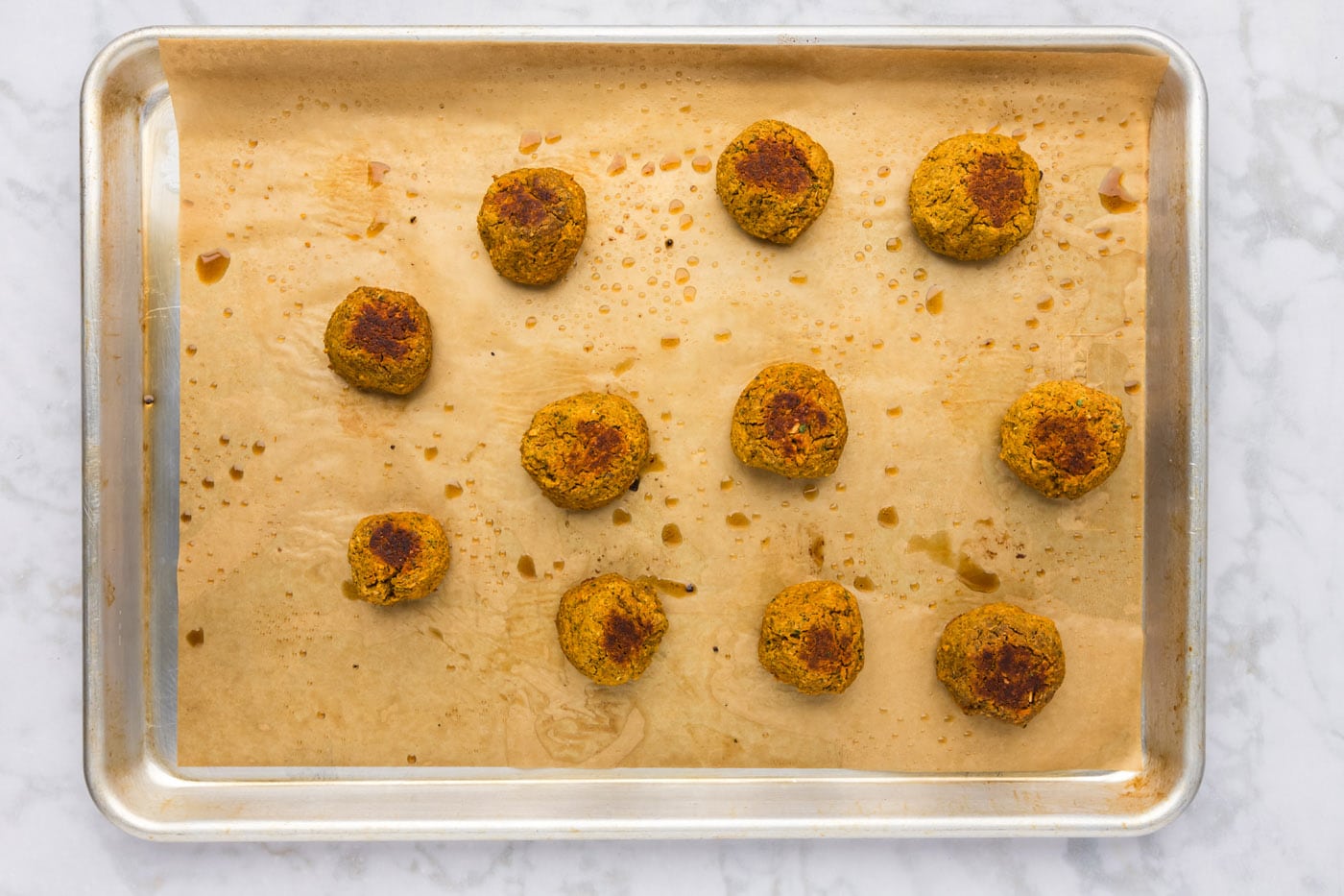 baked lentil meatballs on a cookie sheet