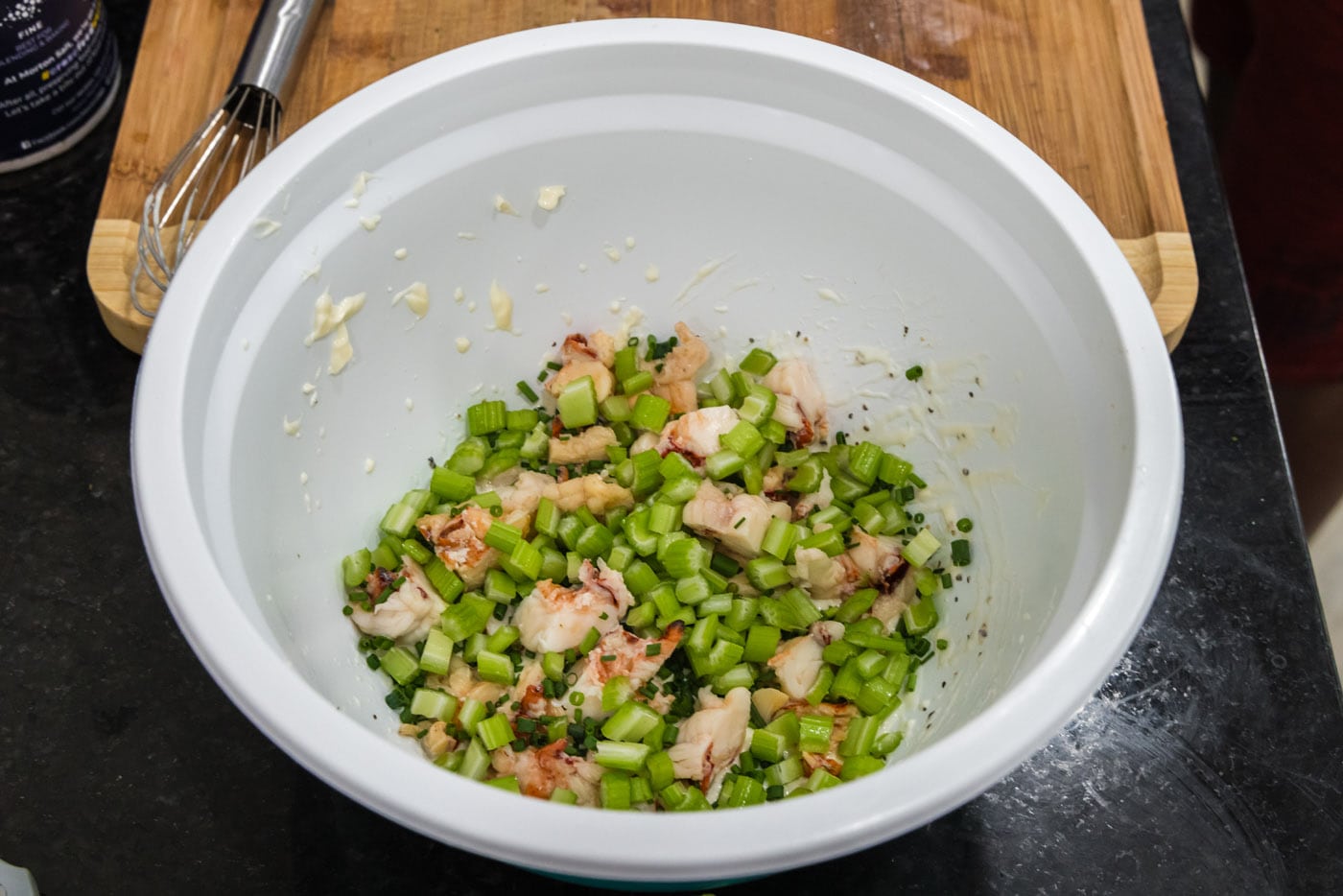 chives and celery added to bowl of dressing and lobster meat