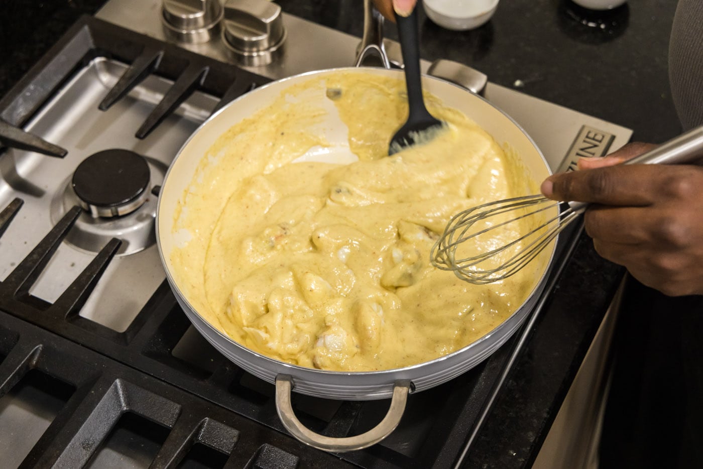 mixing lobster chunks into cream sauce for lobster newburg