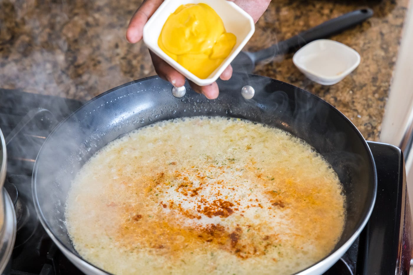 adding yellow mustard to lobster thermidor sauce