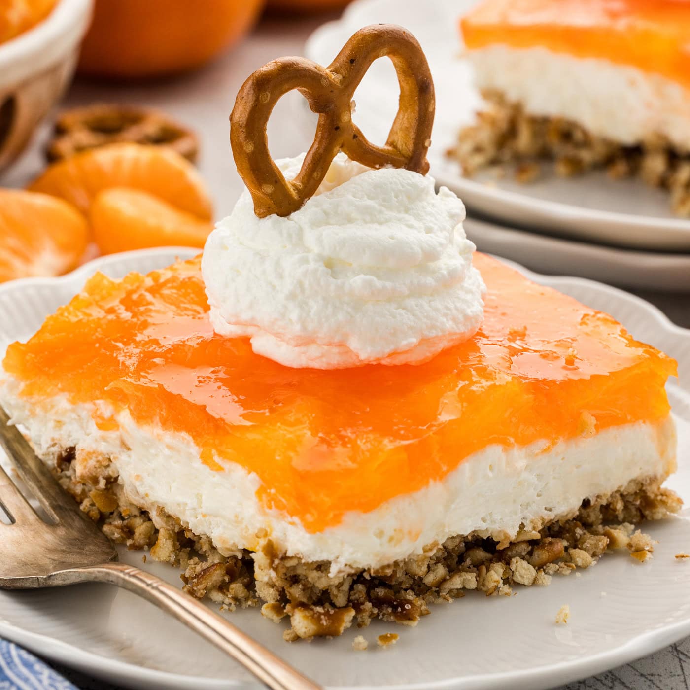 Orange Pretzel Salad on plate with whipped cream